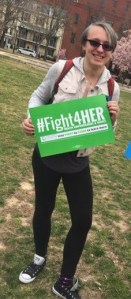 Ashton holding a green #fight4HER sign