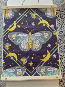 A painting of moths and moons, primarily in yellows and purples