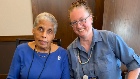 Rachel, a white person with glasses, and Barbara, a Black person with short hair, smiling together