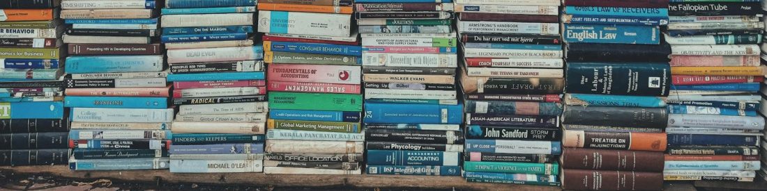 stack of books on wooden shelf